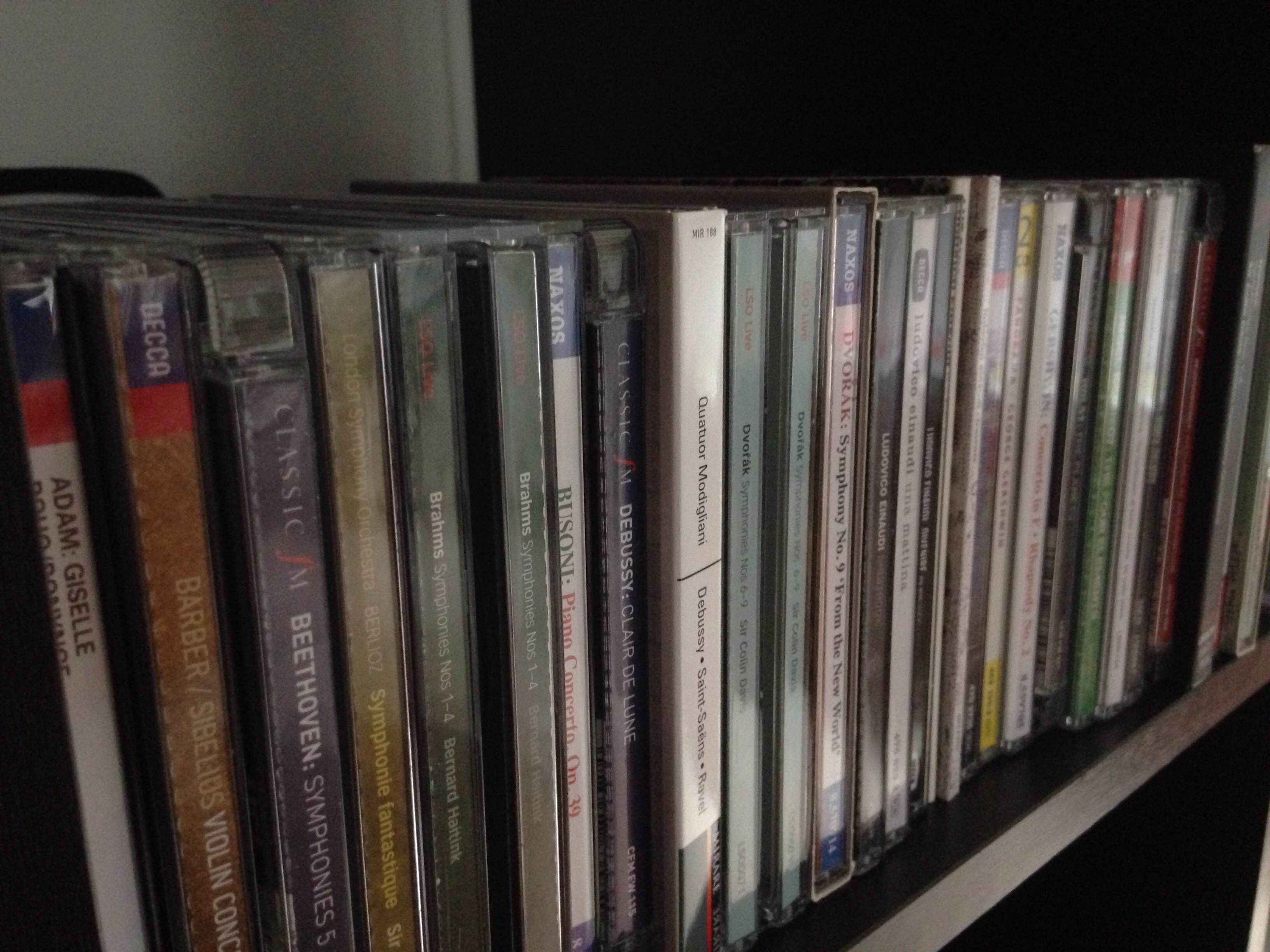 A shelf filled with CD cases, stacked vertically
